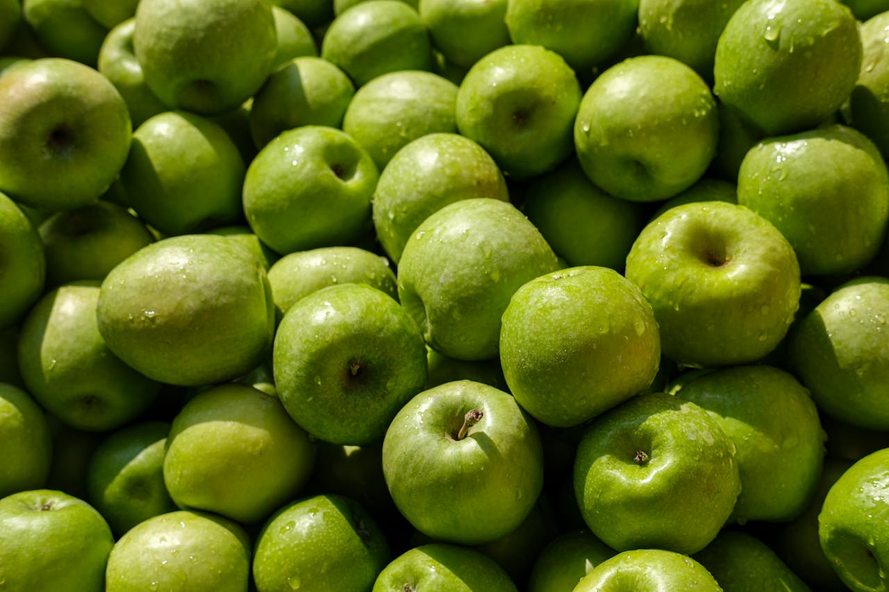 A close-up view of fresh green apples with water droplets, perfect for healthy lifestyle themes.